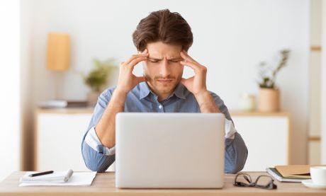 Rad od kuće, glavobolja, posaolaptop, stres, muškarac se drži za glavu